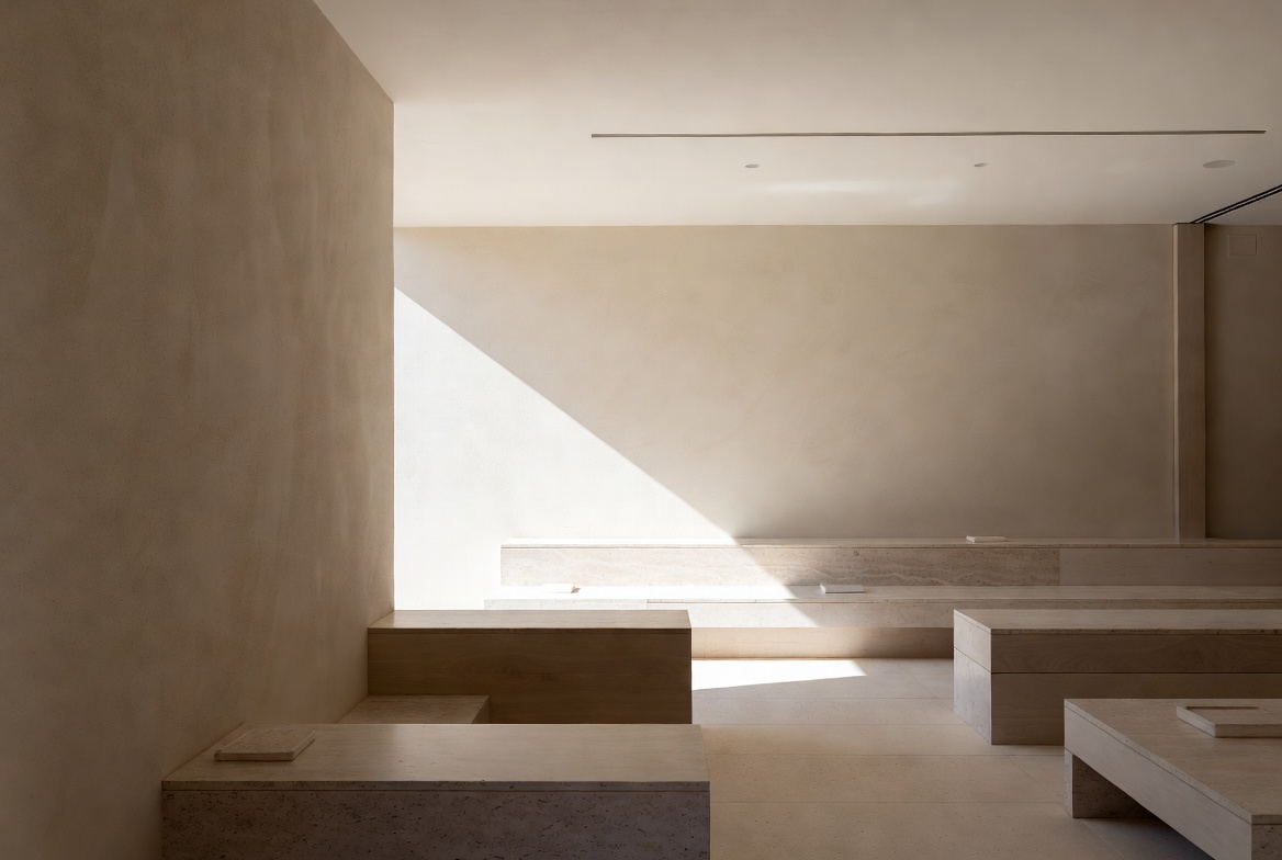 Interior of a Napa Valley winery showing wood, stone, and plaster surfaces in natural light, with seating arranged for quiet conversation and materials allowed to age honestly.
