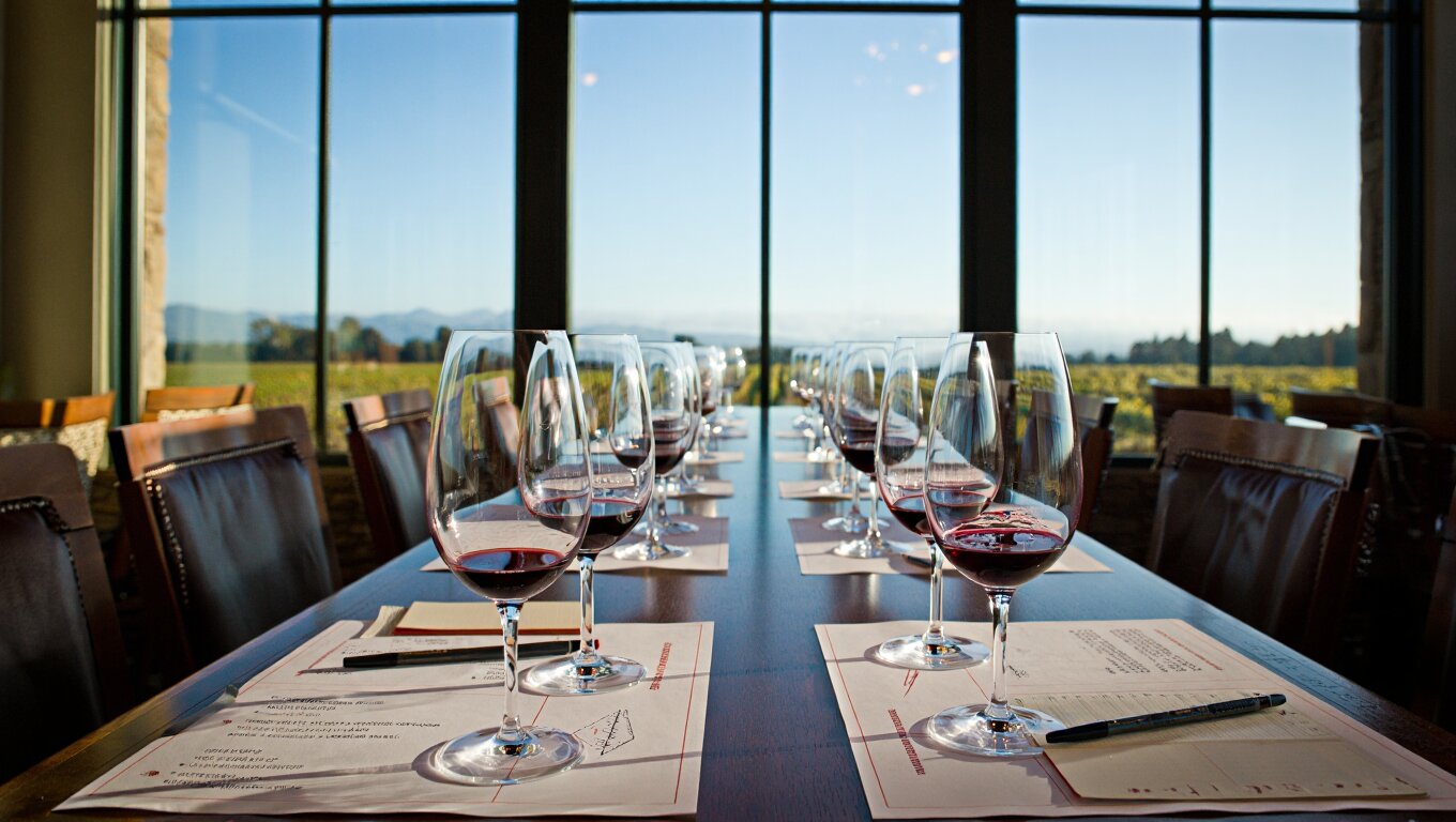 Comparative Cabernet Sauvignon tasting flight in Oakville Napa Valley with structured note sheets and vineyard views, illustrating sensory training and wine education.