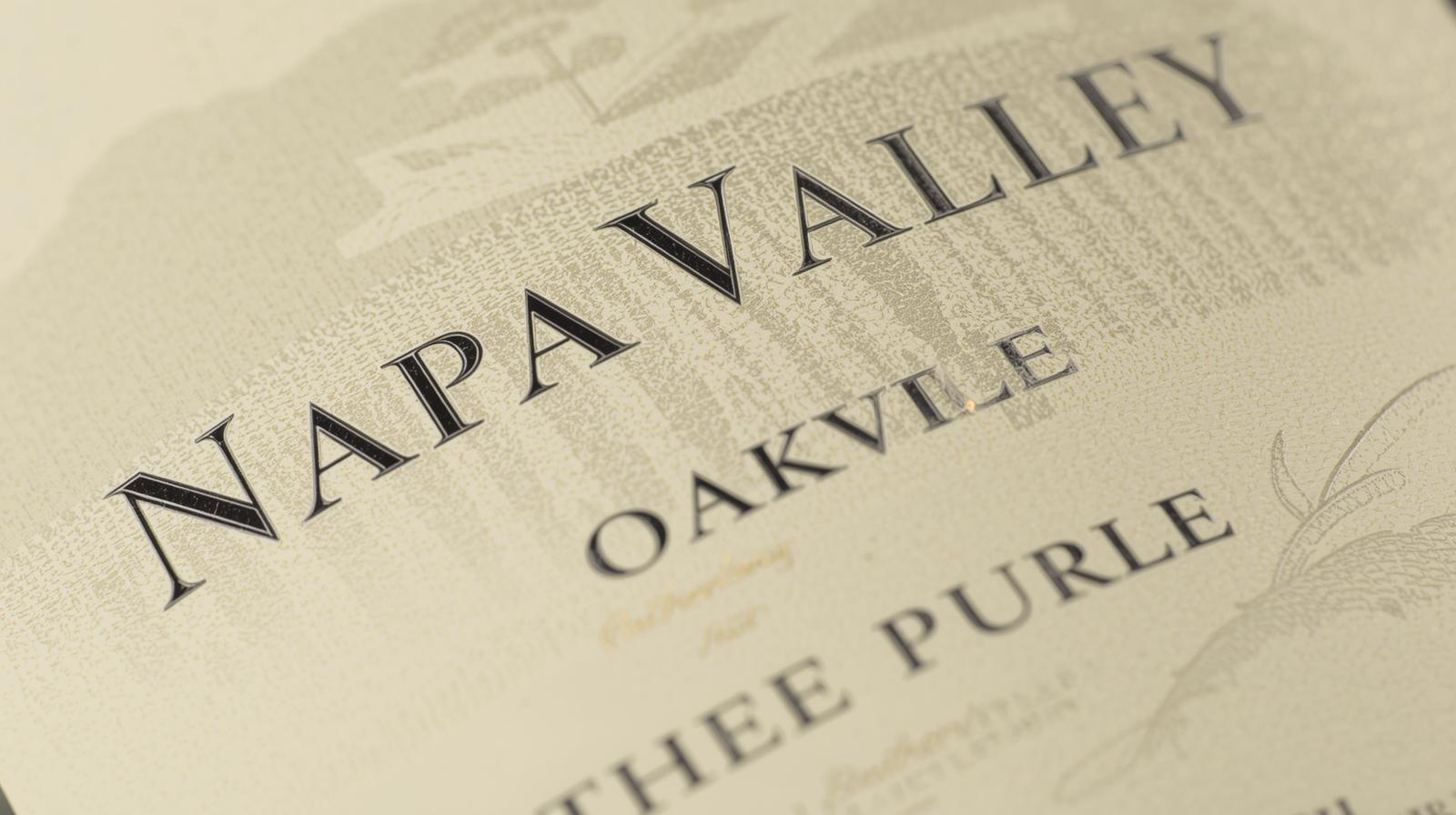 Close-up of a Napa Valley wine bottle label showing Oakville AVA and Napa Valley designation, illustrating conjunctive labeling laws.