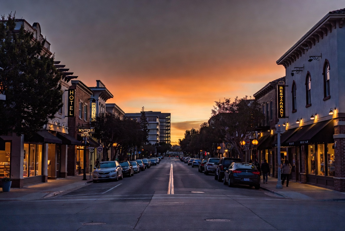 Washington Street in Yountville Napa Valley with boutique hotels, restaurants, and evening pedestrian traffic reflecting the town’s concentrated tourism economy.