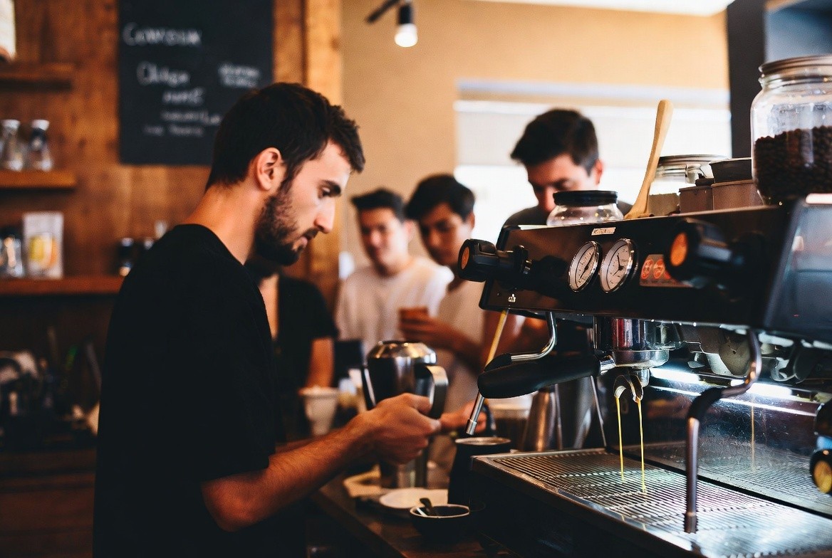Barista pulling an espresso shot at a quiet Napa Valley cafe in the morning with locals gathered at the counter.